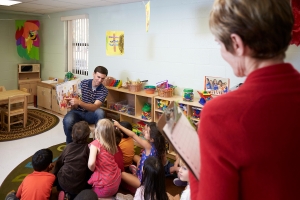 Teacher reading a book to toddlers