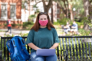 UF student wearing a mask holding a laptop