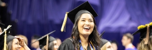 A woman smiles at her graduation.