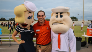 Ryan Chase with two sport mascots from the school where he works.