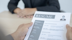 a person holding resume and interviewing another person