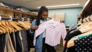 Student looks at clothes in the lending closet.